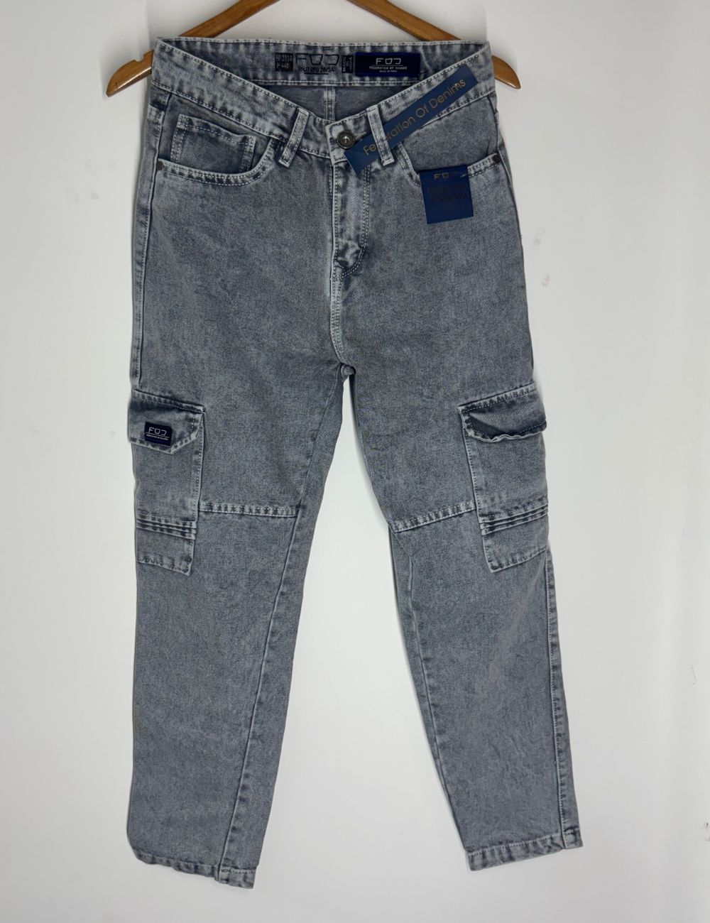 Pair of ash jeans on a hanger against a white background