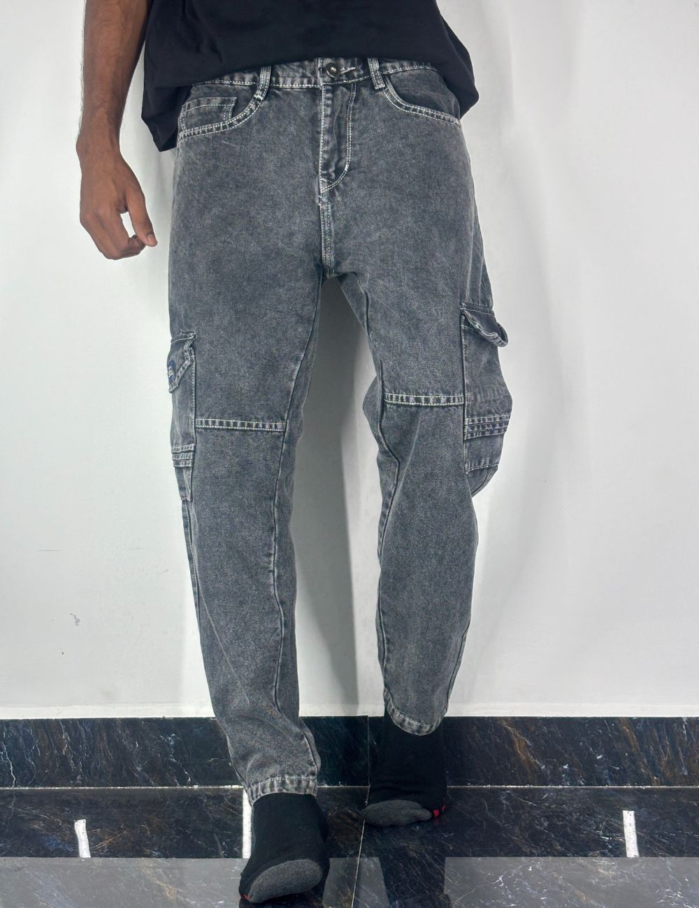 Pair of ash jeans on a hanger against a white background